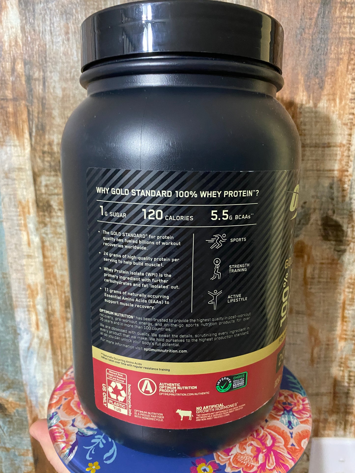 Black protein supplement container with label on a wooden surface